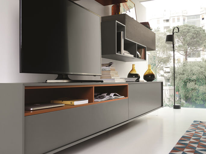 Dark low media unit with an open wood compartment and wall-mounted storage