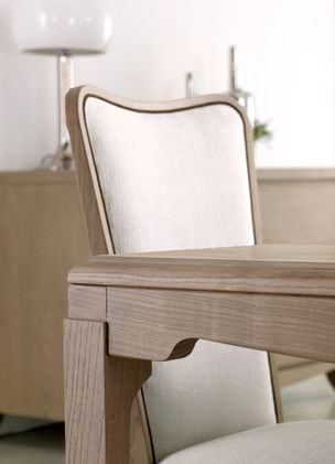 Dettaglio sedia in frassino con schienale e seduta imbottiti e tappezzati con tessuto personalizzabile, con bordino perimetrale a contrasto.