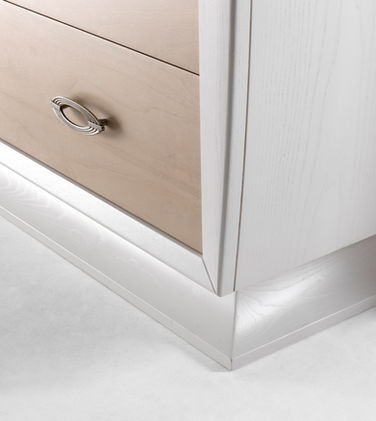 Dettaglio del basamento del comò contemporaneo in frassino con frontali in noce canaletto