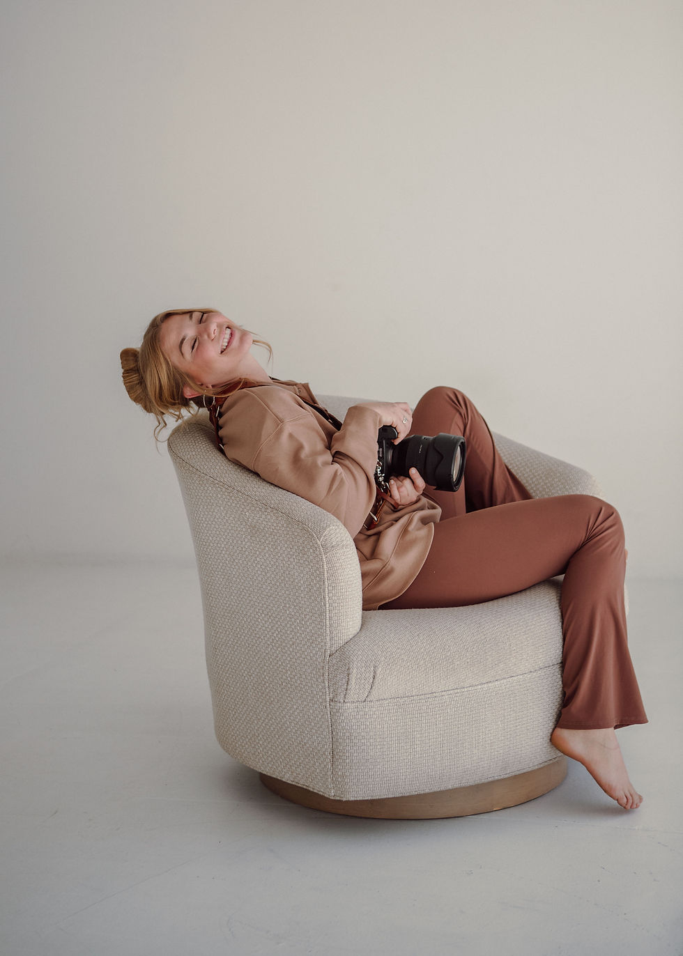 photographer holding camera sitting in chair