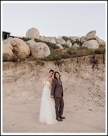 couple in wedding attire standing back to back