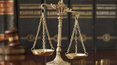 Scales of justice in front of legal books and a gavel, symbolizing changes in health plan regulations