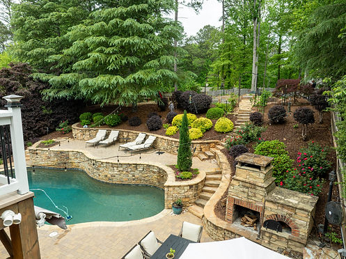 Home garden with pool, chairs, and landscaping.