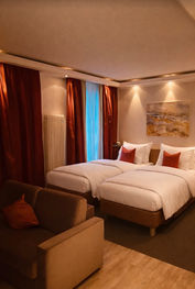 Modernes Hotelzimmer mit Doppelbett und Sitzecke