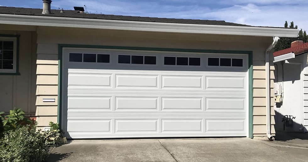 Landscape photo of the front of a white garage doors with some windows at the top