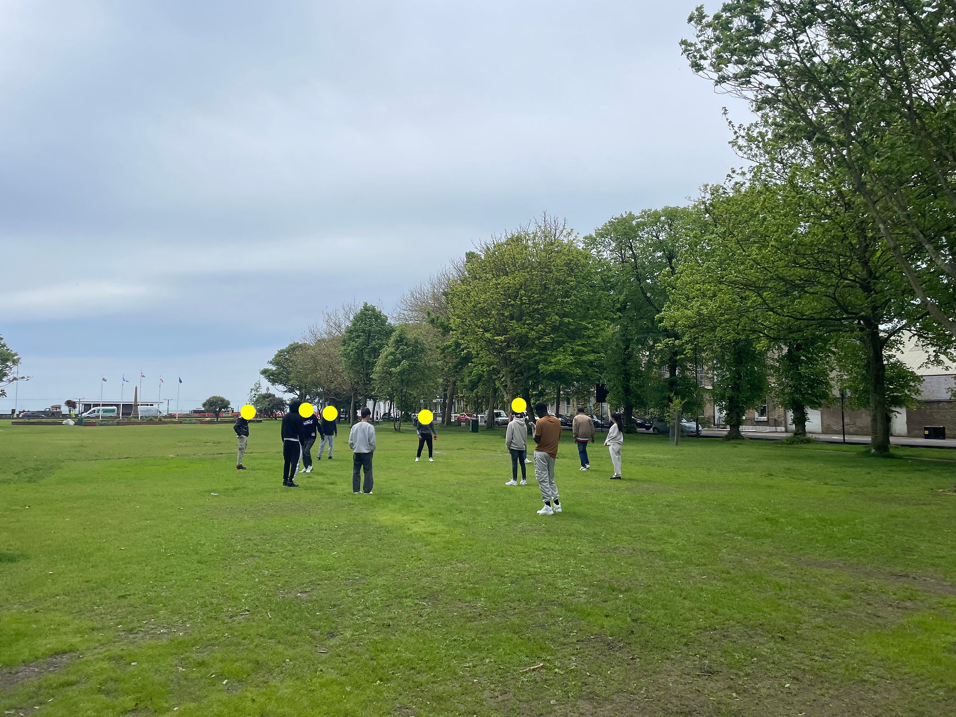 young people playing football in a park