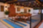 Covered outdoor patio with dining table for six, BBQ grill, and string lights at a furnished West Hills home
