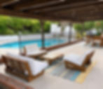 Covered outdoor lounge with comfortable seating overlooking the private pool in a furnished West Hills home.