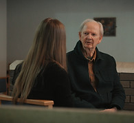 A still from a documentary of two people talking.