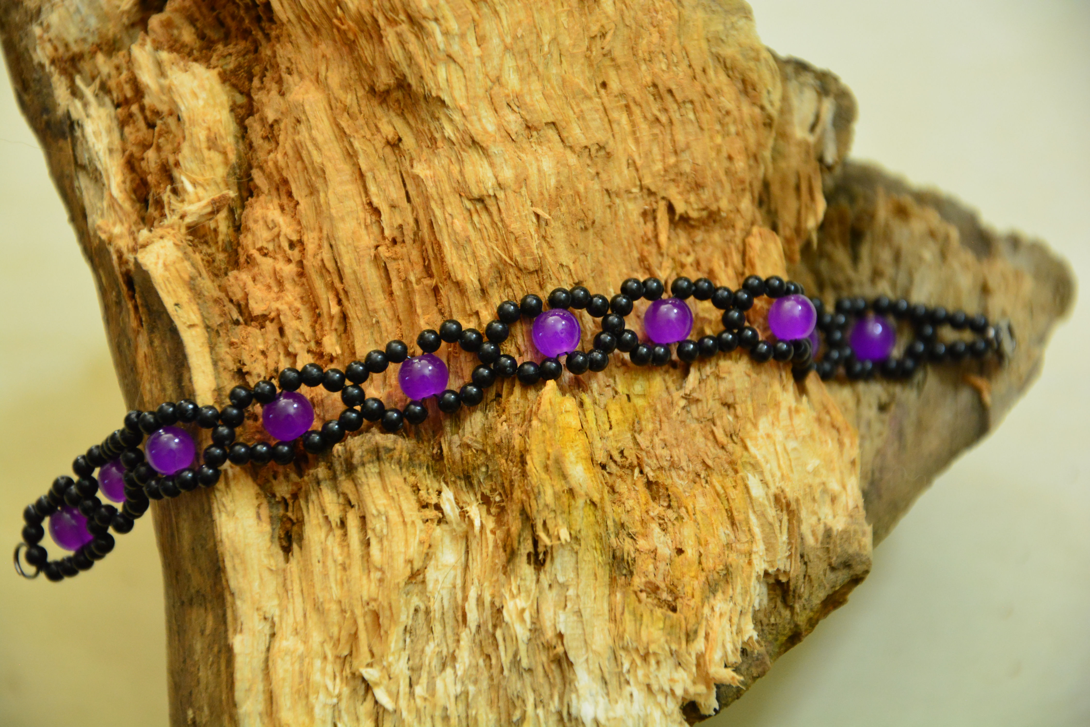 Armband handgewebt nickelfrei – schwarze Rocailles in Wellenform mit lila Glasperlen, schwarzer Karabiner, Unikat