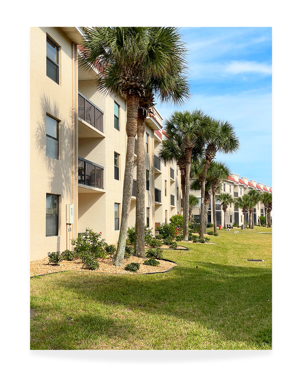 Ocean Village Club condominium buildings surrounded by landscaped grounds in St. Augustine Beach, Florida.