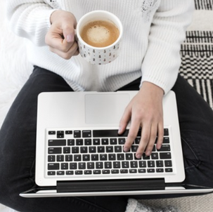 Work-from-home setup with laptop and coffee in a relaxed, minimalist environment.