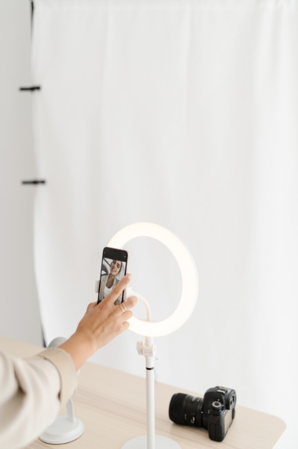 Content creator setting up a smartphone and ring light for filming social media content.