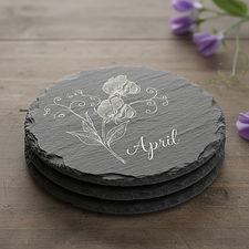 small stack of slate coasters engraved with an image of a sweet pea flower and the words