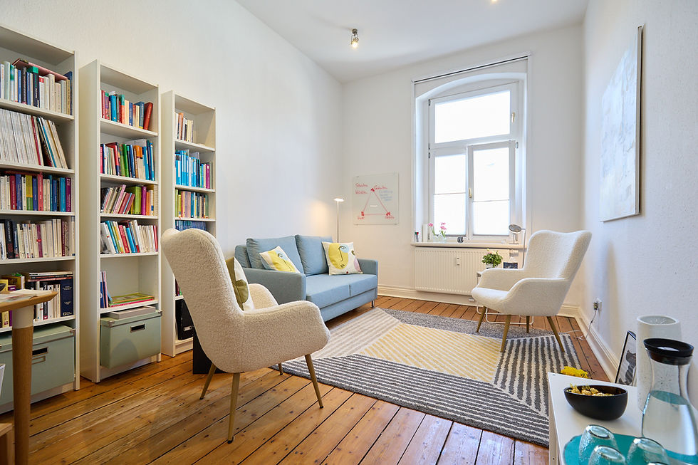 Praxis von Helgard Heindrichs. Gemütlicher Beratungsraum mit Sofa und Büchern.