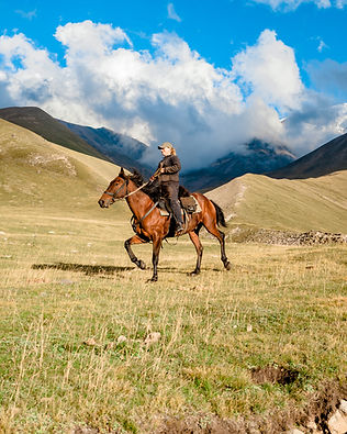 side-view-cowgirl-shepherd-riding-horse-mountain-valley-against-sky-with-clouds.jpg
