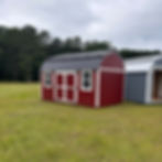 Spacious 10x16 red lofted shed featuring a black metal roof and two windows, perfect for backyard storage or workshop.