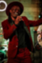 Man in red suit and hat singing
