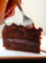 Fork taking a bite from a slice of chocolate cake