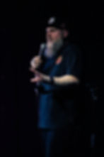 Bearded man speaking into microphone
