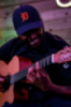Smiling man in D-cap playing acoustic guitar