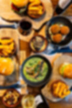 Burgers, fish, fries, and wine on a wooden table