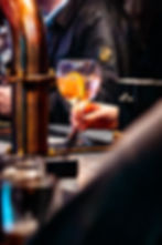 Hand holding a cocktail glass at a bar