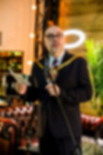 Man in ceremonial chain speaking at event