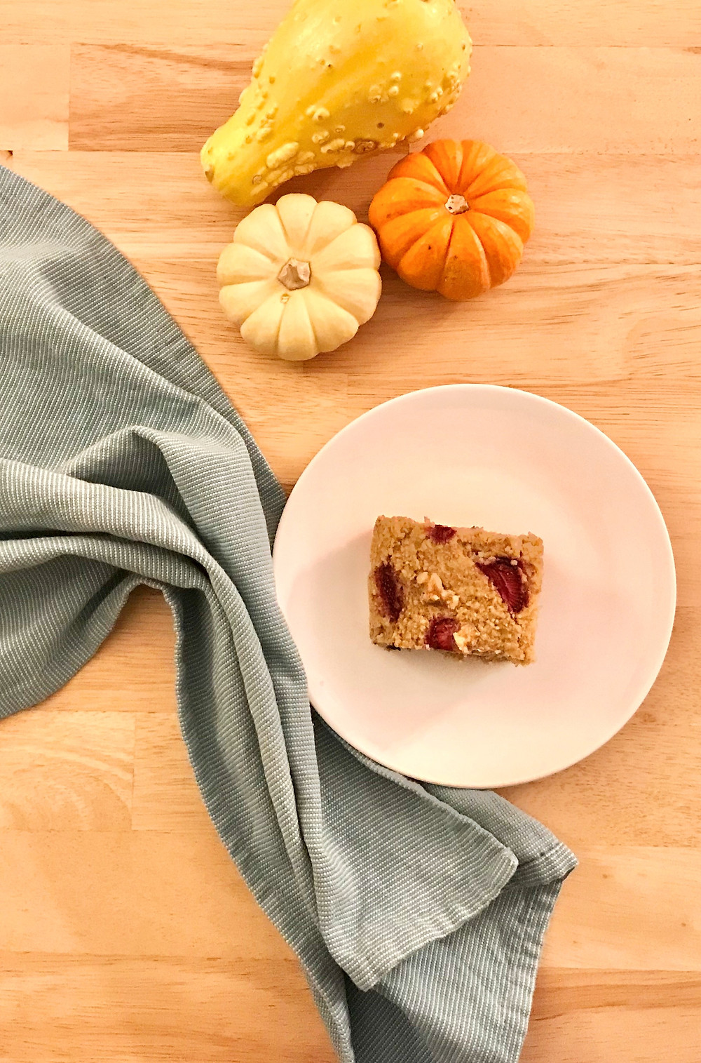 Berry Oat Bar on a plate surrounded by gourds & blue towel