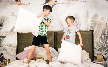 Kinder machen Kissenschlacht im Bett