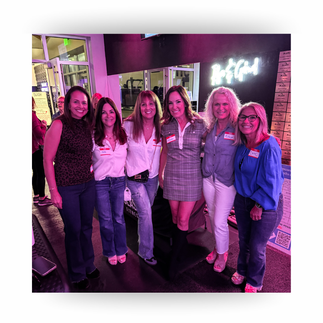 Midlife women smiling together at a wellness event, celebrating friendship, connection, and community support in a vibrant fitness studio setting.