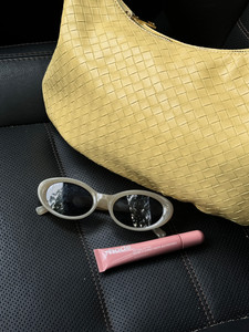 yellow purse with sunglasses and rhode lipgloss