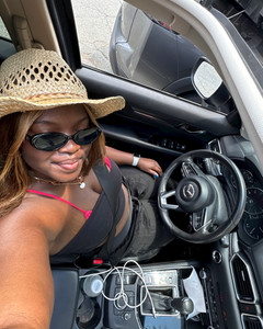 .5 zoom photo of a girl driving wearing a cowboy hat
