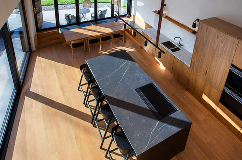 Modern kitchen with black stone kitchen island with hardwood units