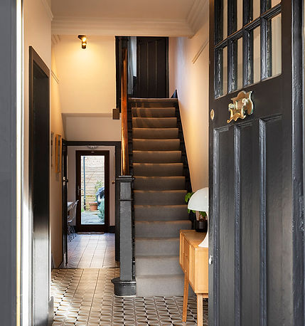 Open door with a view into a period tiled hallway, with view into the kitchen and period staircase