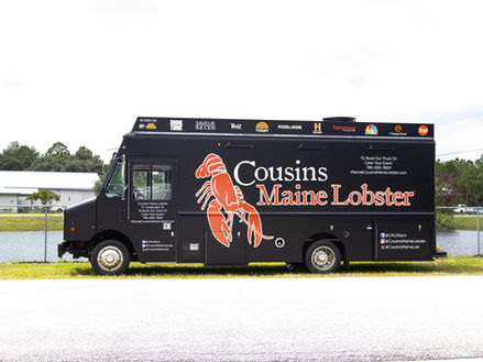 The driver side of the Cousins Maine Lobster food truck, featuring powerful Durawatt generators. Built by Premier Food Trucks, experts in food truck building.