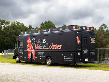 The driver’s side of the Cousins Maine Lobster Custom Food Truck featuring a bold lobster logo, designed for high-traffic visibility. Ideal for entrepreneurs searching for a food truck for sale.