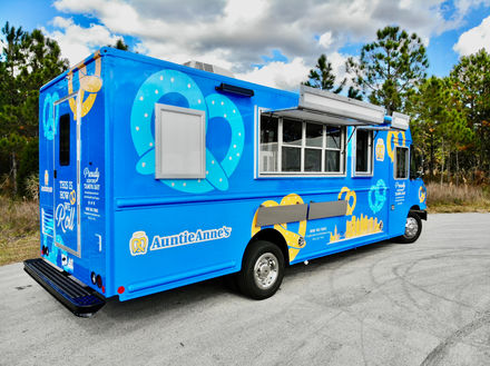 Side view of Auntie Anne's custom food truck with open awnings in Tampa, Florida, built for efficient service by top food truck builder.