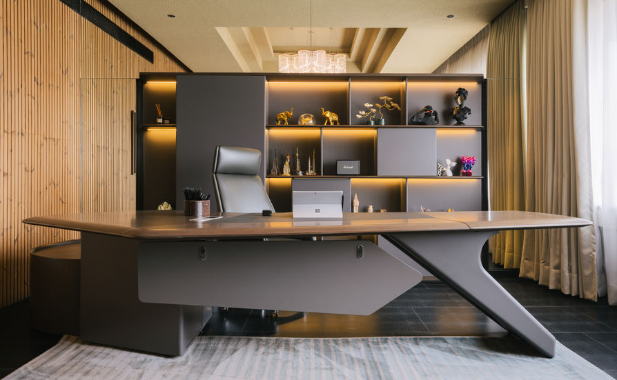 Modern office desk with shelves and ambient lighting.