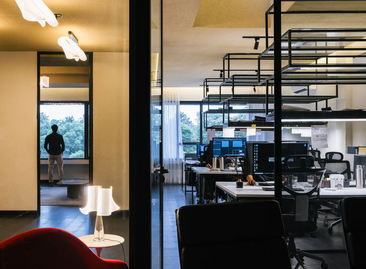 Modern office space with glass walls and desks.