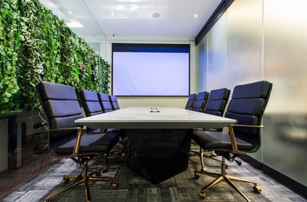 a conference room with a large white table and black chairs
