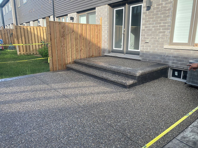 A picture showcasing neatly constructed concrete stairs and the backyard area of a house