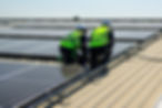 Engineer and technician using laptop checking and operating solar panels system on rooftop