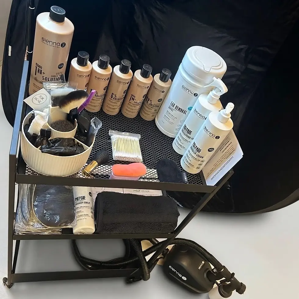 Studio photography of a mobile salon trolley filled with tanning solution bottles, application tools, and cosmetic accessories. The arrangement appears professional, clean, and organized.