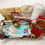 Thumbnail: gift basket with baby products, new mom products, baby wipes, plush toy, baby lotion, chocolates, holiday gift