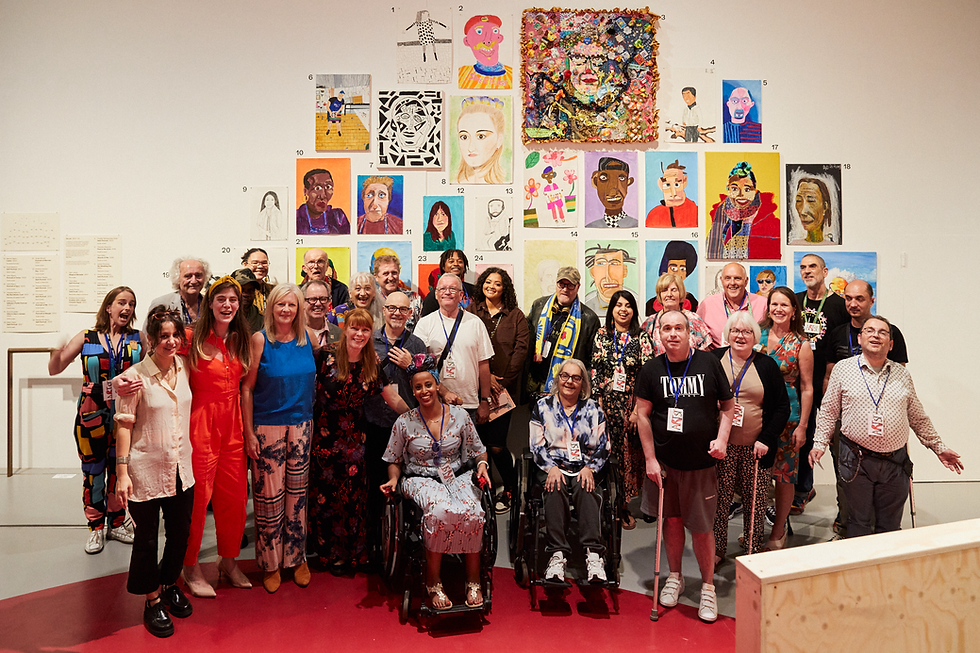 Group of diverse people smiling in front of a colorful art display. Some use wheelchairs. The mood is joyful and inclusive.