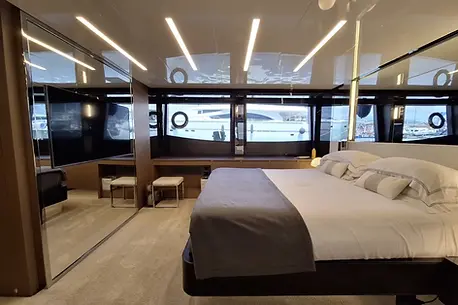 Full-beam master suite on the Riva Perseo 76 luxury yacht with contemporary furnishings.