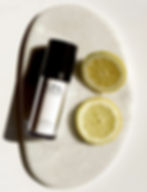 White SPA product bottle with lemon halves on a stone tray
