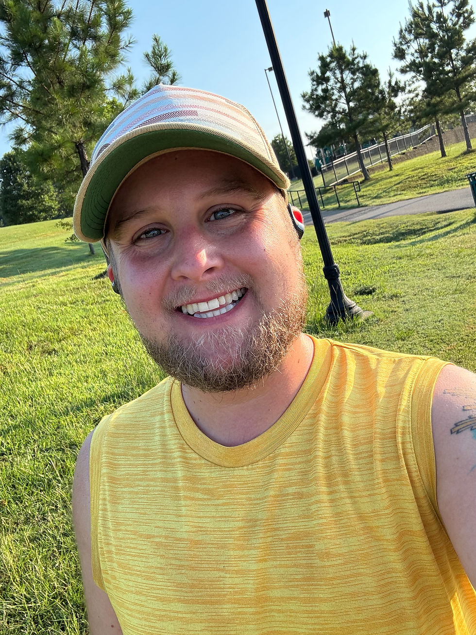 young man in a yellow shirt and hat at the park running