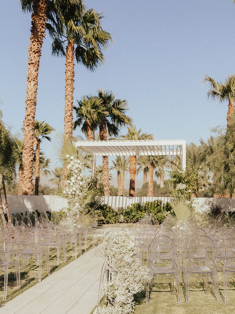 wedding ceremony setup with white florals and clear chairs in the rose garden at The emerson estate